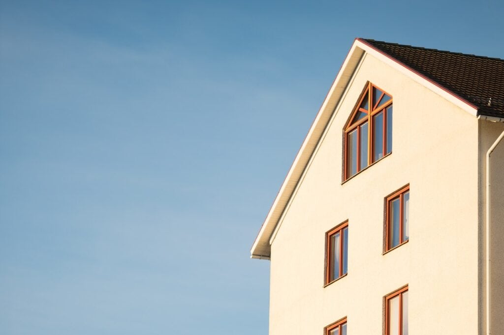 Hvid facade af stor bygning med blå himmel